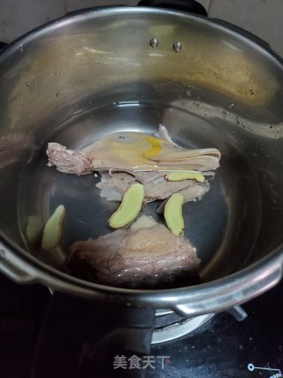 3把鸭骨，姜片放入高压锅加入适量的水盖盖大火煮开转中火压15分钟。 
